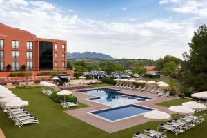 an image of a resort with a pool and chairs and umbrellas at Dolce by Wyndham Barcelona Resort in Sant Esteve Sesrovires