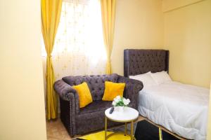 a bedroom with a bed and a couch and a table at Palisades in Voi