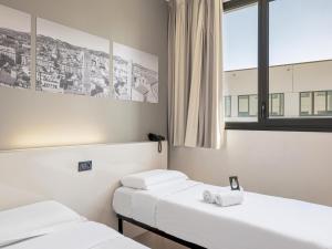 Łóżko lub łóżka w pokoju w obiekcie B&B HOTEL Bologna
