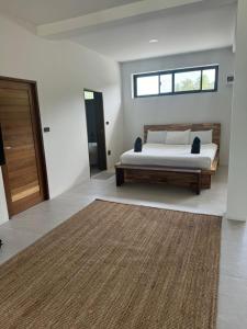 a bedroom with a bed and a window and a rug at Muse&Mingle Contemporary Beachfront Loft in Chaloklum