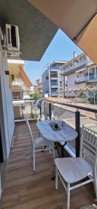 a patio with a table and chairs on a balcony at Darius Lux Apartments in Paralia Katerinis