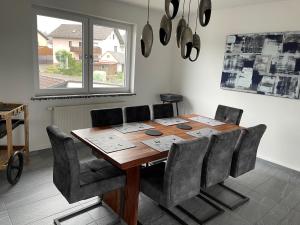 a dining room table with chairs and a large window at Ferienwohnung im Spessart-Steinbach in Lohr