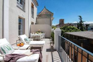 a balcony with chairs and a table on a building at Terrace Suite City Center in Granada
