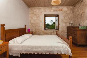 un dormitorio con una cama y una ventana en Villa Ampeli, en Vasilikos