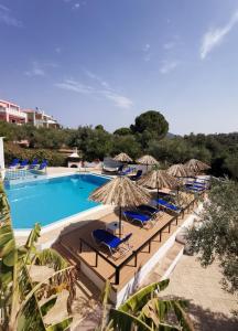 una piscina con sedie e ombrelloni di Lofos Strani a Città di Zante