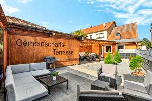 a patio with a couch and chairs in front of a building at Garten - Bergblick - SmartTV - Parkplatz - HarzLounge in Thale