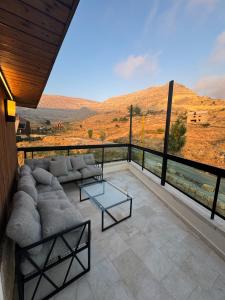 ein Wohnzimmer mit einer Couch und einem Glastisch in der Unterkunft A Suites Apartments Faraya in ‘Ayn Barq