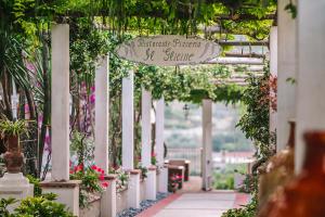 a garden walkway with a sign that reads backyard pearl summer at Hotel Giordano in Ravello