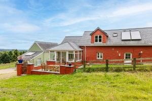 a red house with a fence in front of it at Plas Drygarn Ty Coch Crymych in Crymych
