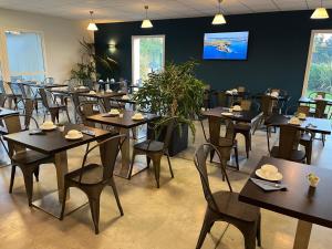 a dining room filled with tables and chairs at Hotel Caiman in Pierrelatte +51 photos