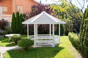 a white gazebo in the middle of a yard at Flowers Oasis Studio Vrnjačka Banja in Vrnjačka Banja