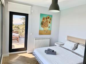 a bedroom with a bed and a painting on the wall at Chalet a estrenar, espectaculares vistas a la montaña in Torremocha de Jarama +33 photos