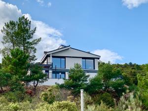 a house on top of a hill with trees at Chalet a estrenar, espectaculares vistas a la montaña in Torremocha de Jarama