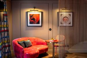 a living room with a red chair and a table at Upon Angels - Adults Only in Lisbon