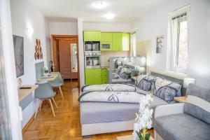 a living room with two beds and a kitchen at Flowers Oasis Studio Vrnjačka Banja in Vrnjačka Banja