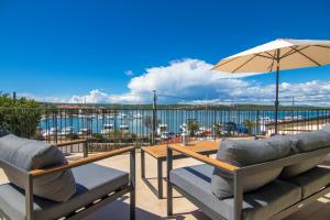 a patio with chairs and an umbrella and a view of the water at Villa Marin in Klimno