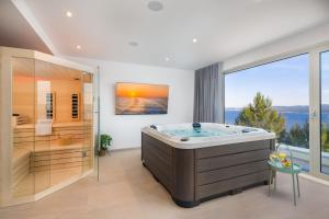 ein großes Badezimmer mit großer Badewanne und großem Fenster in der Unterkunft Boutique Villa Nana in Čelina