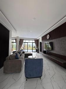 a large living room with a couch and a tv at VILLA NEOM PUNCAk in Sampal 2