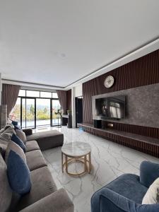 a large living room with couches and a tv at VILLA NEOM PUNCAk in Sampal 2