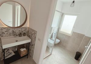 モンテネーロ・ディ・ビザッチャにあるFeudi di Bisacciaの洗面台、鏡、トイレ付きのバスルーム +6枚の写真