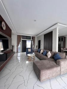 a living room with a couch and a table at VILLA NEOM PUNCAk in Sampal 2