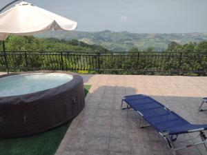 a hot tub with a bench and an umbrella at B&B Cuccagna in Rocca deʼGiorgi