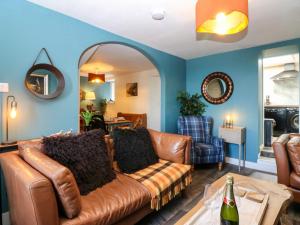 a living room with a brown leather couch at West Pier Cottage in Macduff
