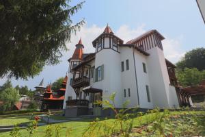 a large white house with turrets on a lawn at Turul Villa in Sovata +89 photos