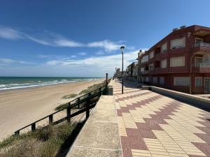 a boardwalk leading to a beach with a building at Valencia Frente al mar in Valencia