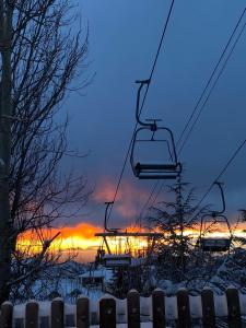 ein Skilift mit einem Sonnenuntergang im Hintergrund in der Unterkunft El Alamo Sierra Nevada APTO NUEVO 2 habitaciones 2 baños en zona baja in Sierra Nevada