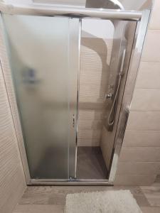 una doccia con una porta in vetro in un bagno di Terrazza sul mare a Scaletta Zanclea