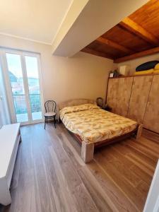 una camera da letto con un letto e una sedia di Terrazza sul mare a Scaletta Zanclea