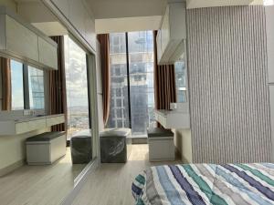 a bedroom with a bed and a large window at Apartement 2 Bedroom And 1 Living Room A22701 Pollux Habibi Batam Centre in Batam Center