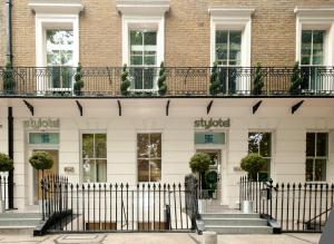 a white building with a fence in front of it at Stylotel in London
