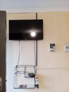 a flat screen tv hanging on a wall at Zone 4 Motel and spa in Polokwane +2 photos