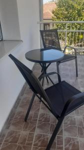 a black chair and a table on a patio at Udobna Dvokrevetna Soba Sa Terasom #2 in Mladenovac