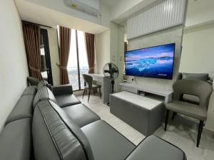 a living room with a couch and a flat screen tv at Apartement 2 Bedroom And 1 Living Room A22701 Pollux Habibi Batam Centre in Batam Center