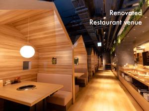 a restaurant with wooden walls and tables and a row of sinks at Hotel Naturwald Furano in Furano