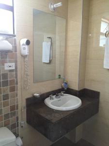 a bathroom with a sink and a mirror and a toilet at Hotel Sogamoso Real in Sogamoso