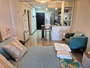 a living room with a bed and a kitchen at Departamento Parque - Neuquén in Neuquén