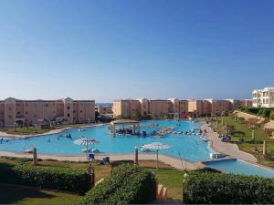 a large swimming pool with people in a resort at Chalet 3 bedrooms Venus 2 Resort in Dawwār Ibrāhīm Abū Shunaywīr