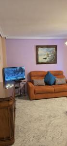 a living room with a couch and a flat screen tv at Apartamento Cozy Inns Beach in Torremolinos