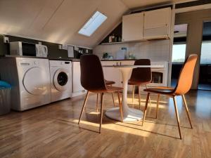 a kitchen with a table and three chairs in it at 2 etasje Jutulveien 6 in Tønsberg