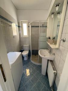 a bathroom with a sink and a toilet and a shower at Mesogaia Home Near ATH Airport in Markopoulo