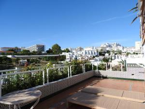 a balcony with a bench and a view of a city at Burriana Casa Molli in Nerja