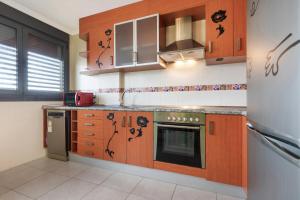 a kitchen with wooden cabinets and a stove at La casa di Gianfranco in Puerto del Rosario