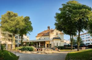 ein Gebäude in einer Straße mit Bäumen in der Unterkunft Asam Hotel in Straubing