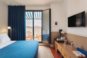a hotel room with a blue bed and a balcony at Hotel Casa Bonay & Spa in Barcelona