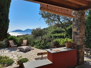 Un patio con mesa y sillas y el mar. en Villa Nilla, en Tellaro
