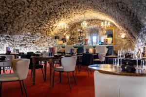 un ristorante con tavoli e sedie e un muro di pietra di Château de Trigance a Trigance Altre 37 foto